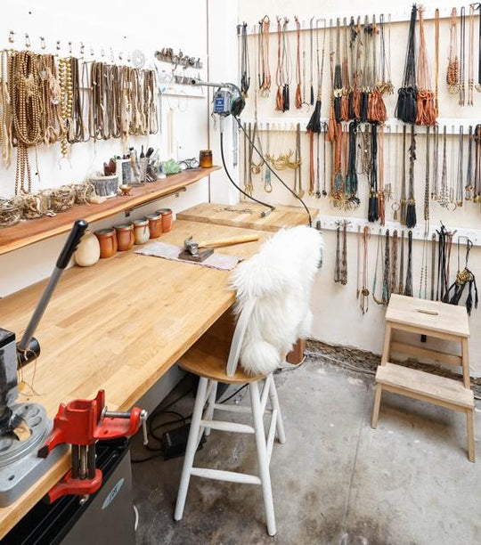 Marisa Mason back of shop with necklaces and work bench
