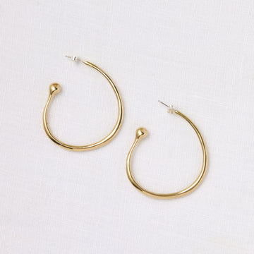 Sweeping large brass hoops that end in small rounded balls - Marisa Mason
