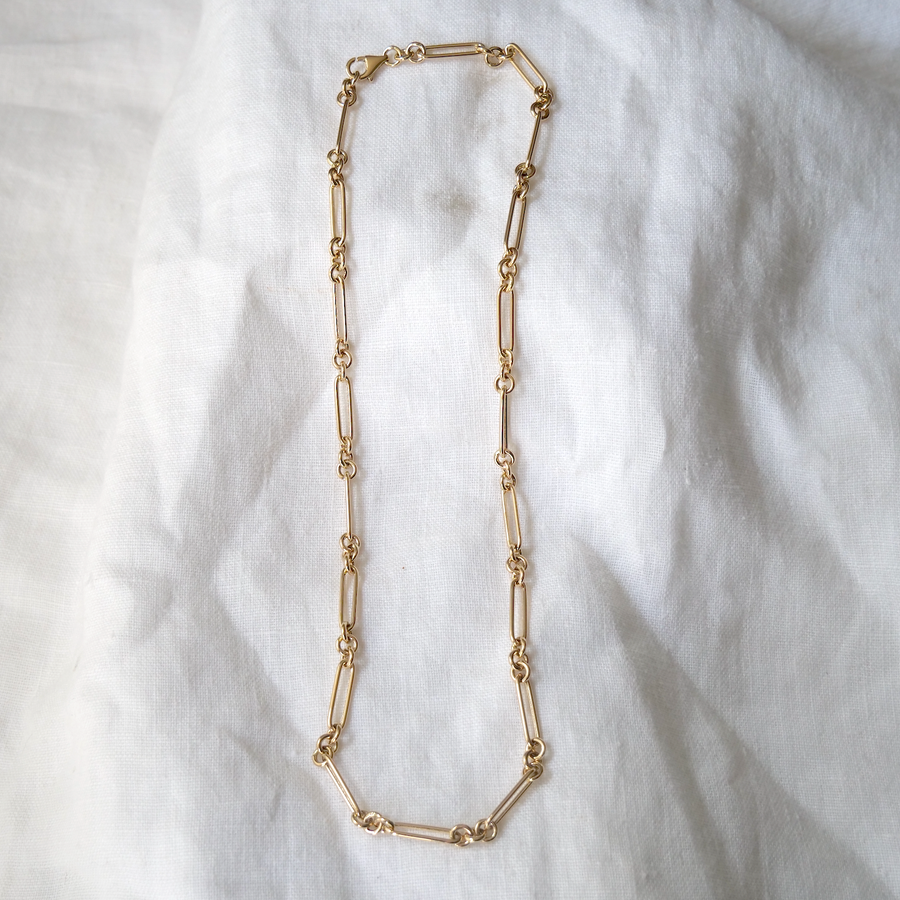 14K Handmade long Link Necklace, hollow links that come together to make a long gold necklace, on white linen backdrop