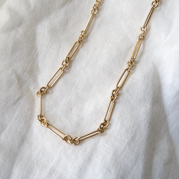 14K Handmade long Link Necklace, hollow links that come together to make a long gold necklace, on white linen backdrop