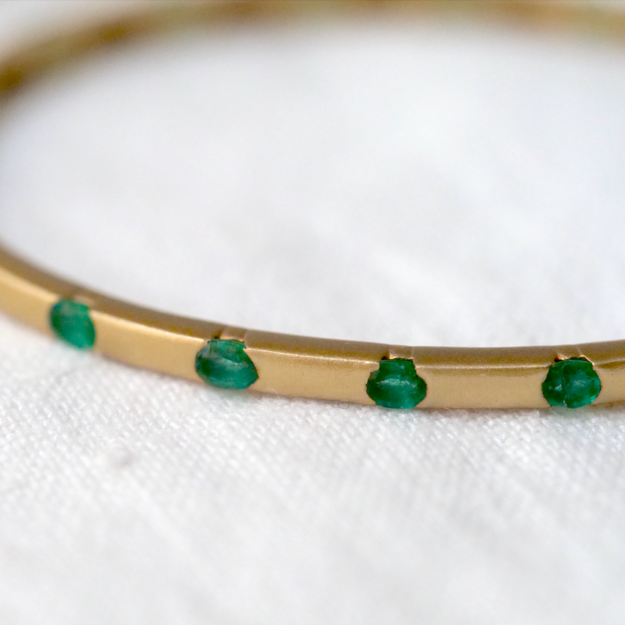 Stunning emerald and 14k yellow gold bangle, with 18 emeralds evenly spaced around it. Hinge clasp, oval shape for comfortability.