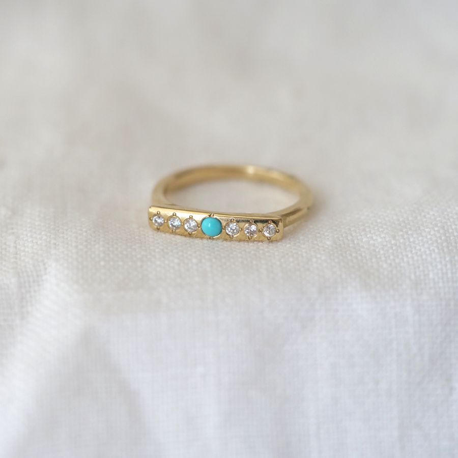 14k ring is set with 1 sleeping beauty turquoise point and 6 white diamonds on a perfectly smooth face