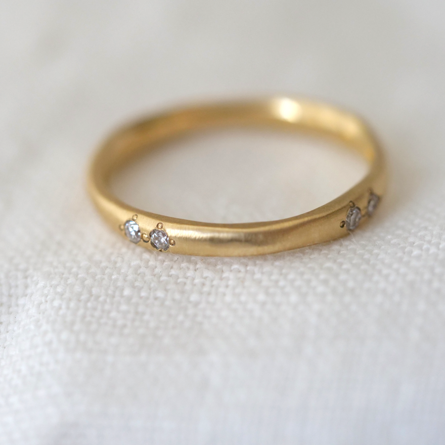 Wavy natural eternity band in 18k yellow gold, with eight 1.6mm diamonds set around the band