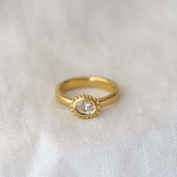 delicate granulation detail around a beautiful white oval diamond is the perfect twist on a classic engagement ring