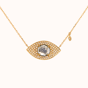 A solid gold eye shaped pendant with a large grey diamond slice at the center, and many small white diamonds pave set around it