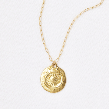 A Rebirth Medallion Necklace by Marisa Mason Jewelry, with a sunburst design, displayed on a plain white background and featuring a paperclip-style chain.
