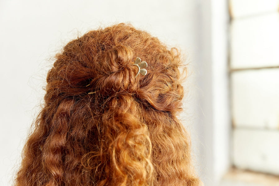 brass hair pin 4 inches long with three little petals along the top, in models hair holding it up-Marisa Mason Jewelry
