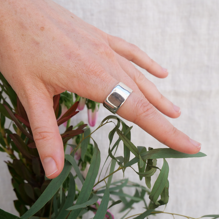 Wide band silver ring with subtle and slight natural texturing on model