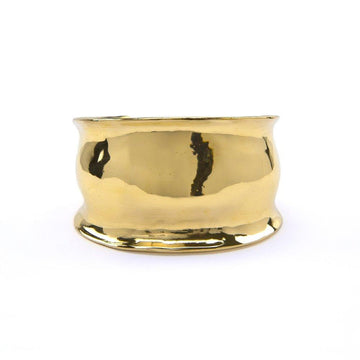 Wide cuff with high shine finish, with a curved texture and ridged edges, made of brass