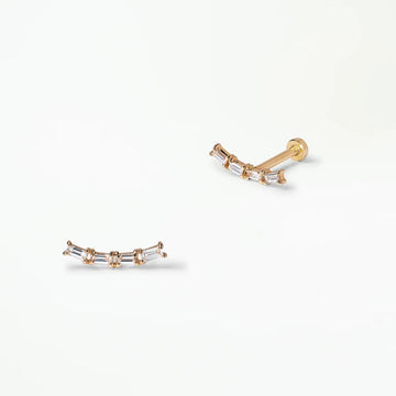 Pair of gold studs with four baguette diamonds on a white background