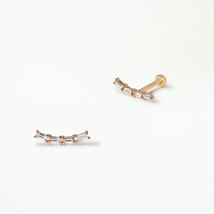 Pair of gold studs with four baguette diamonds on a white background
