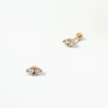 Pair of gold earrings with clear gemstones on a white background