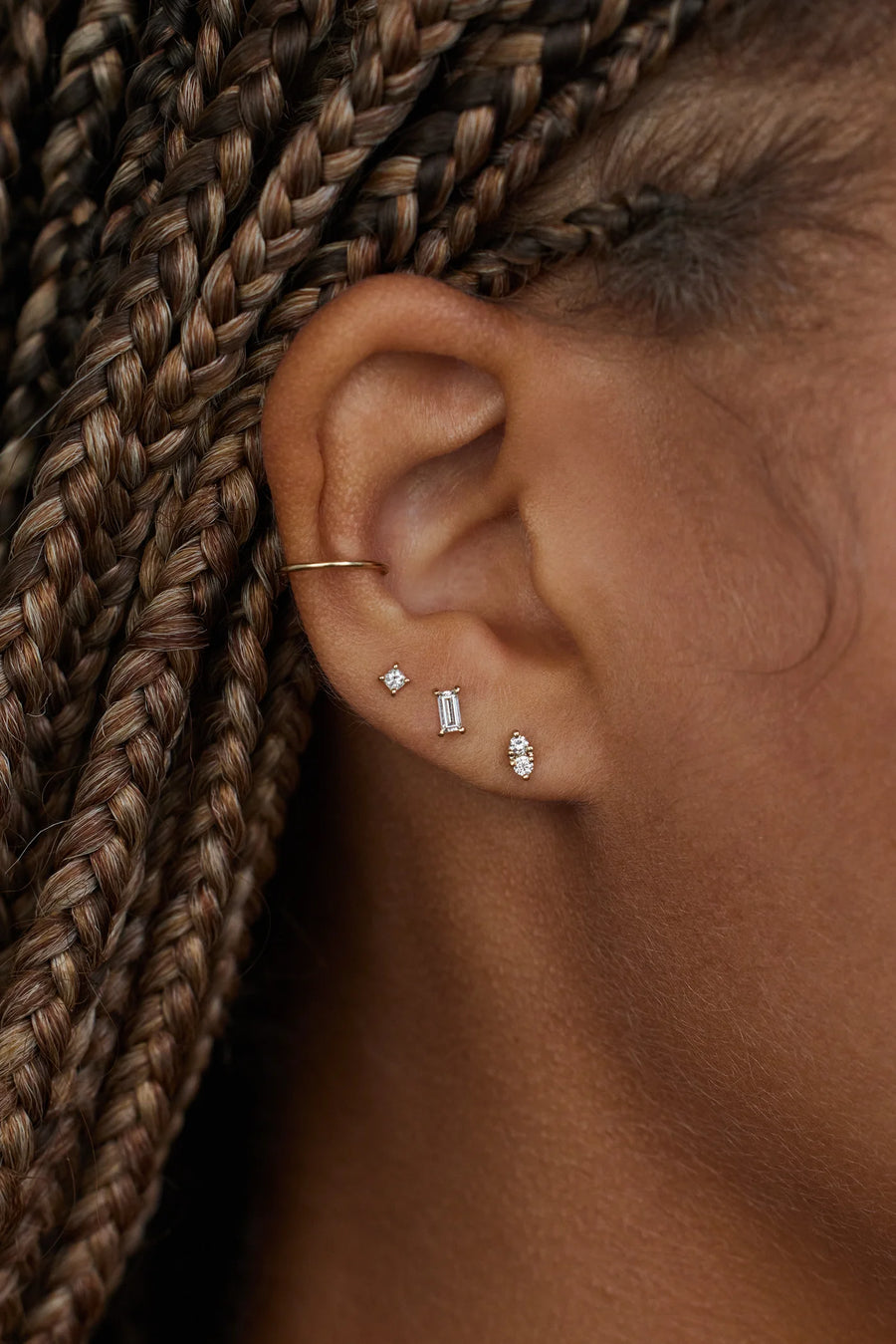 Close-up of an ear with earrings and braided hair