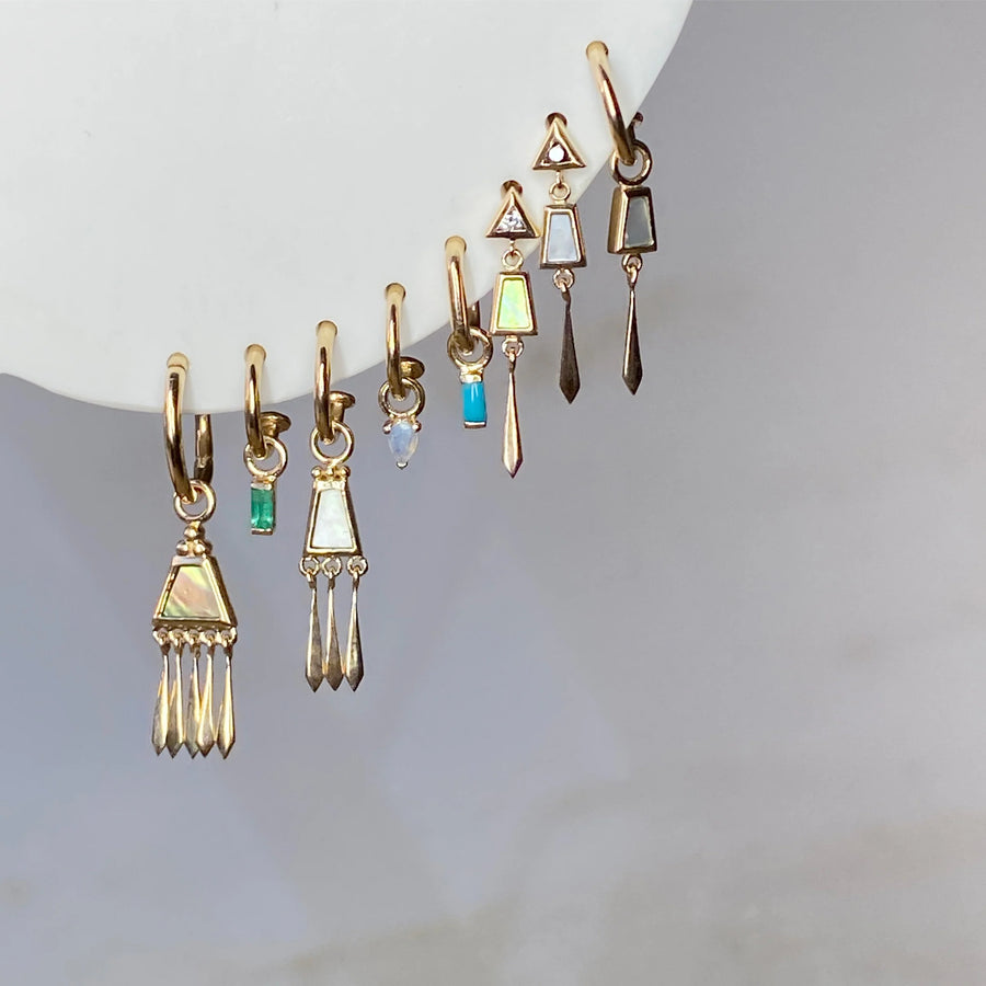 Set of gold earrings with various designs on a white surface