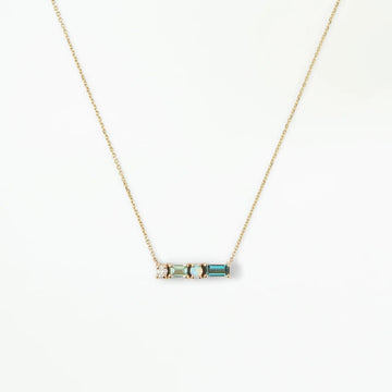 Necklace with a small gold pendant set with a diamond, light green tourmaline baguette, opal and dear teal tourmaline baguette, on a white background