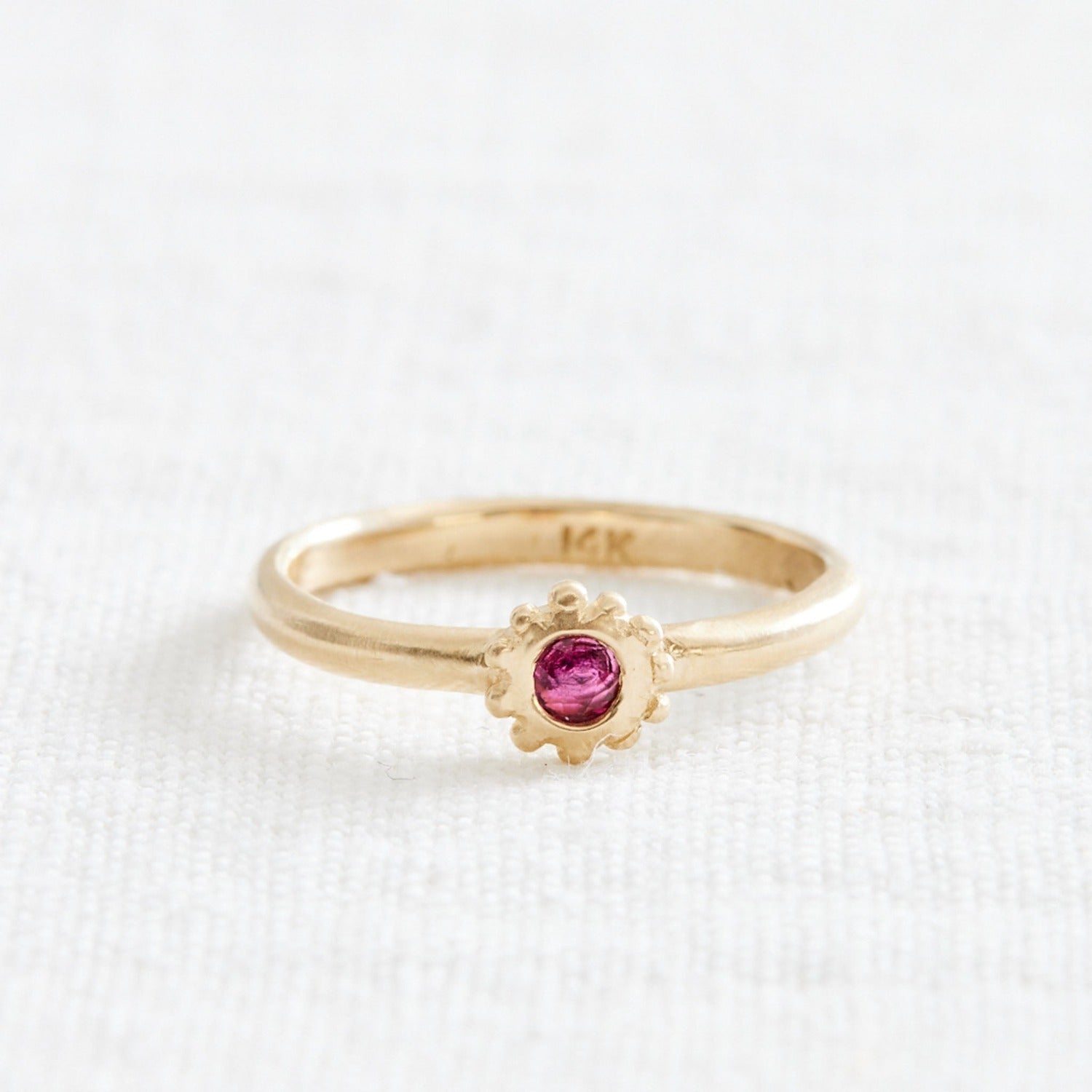 gold ring with pink stone and gold granulations about it