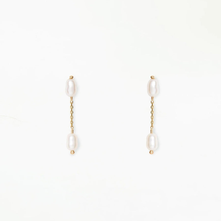 Two delicate freshwater pearls are connected by a sparkling gold chain