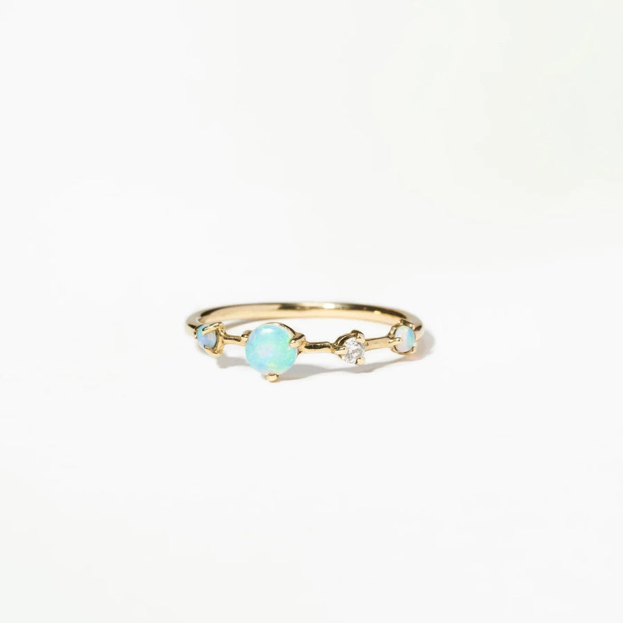 Gold ring with opals and a white diamond on a white background