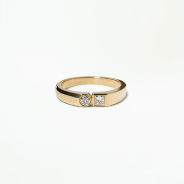 Two diamonds–one round and one square–juxtapose each other, creating two different sides of a single, modern signet ring