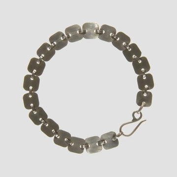 Silver bracelet with a hook clasp on a light gray background