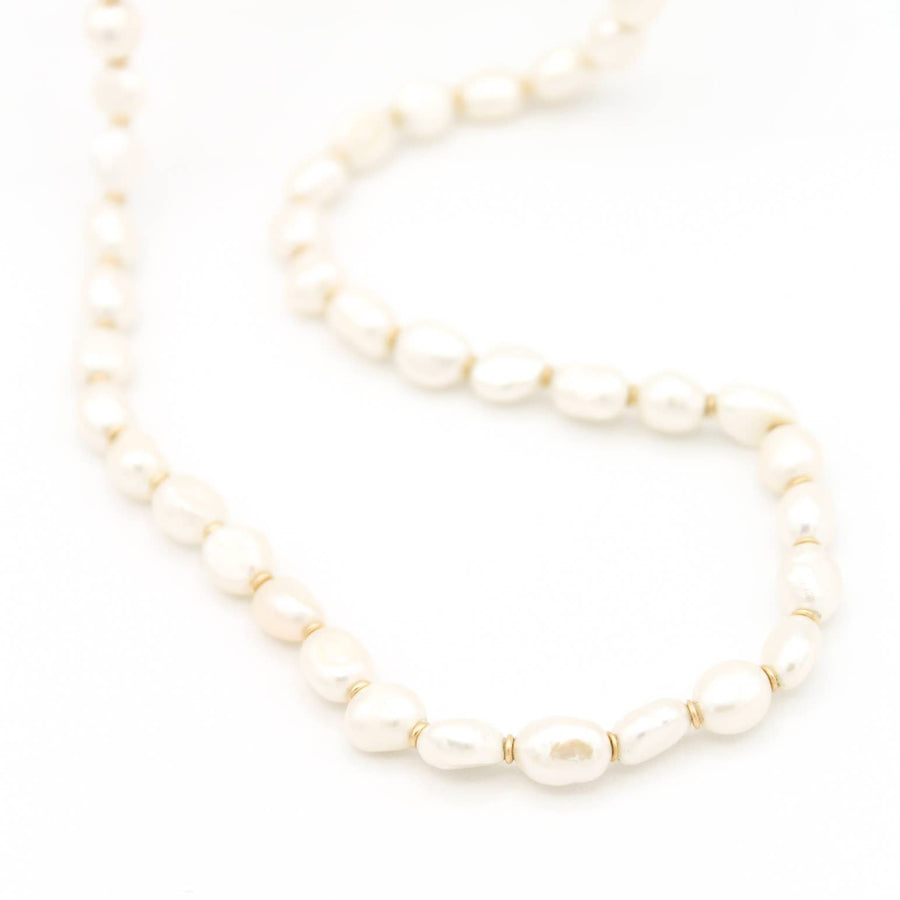 A strand of freshwater pearls that are all irregular shaped, with added 14k gold filled disk beads added to separate each pearl.