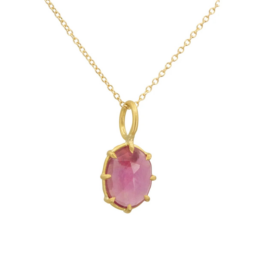 Gold necklace with a pink gemstone pendant on a white background