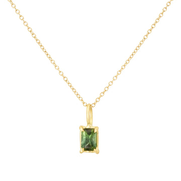 Gold necklace with a green gemstone pendant on a white background