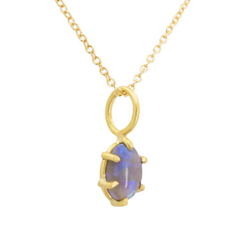 Gold necklace with a pendant featuring a blue gemstone on a white background