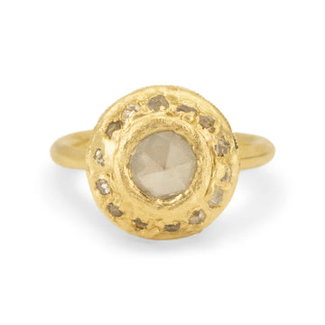 rose cut gray diamond at the center of a large disk of gold with small gray diamonds set all around it