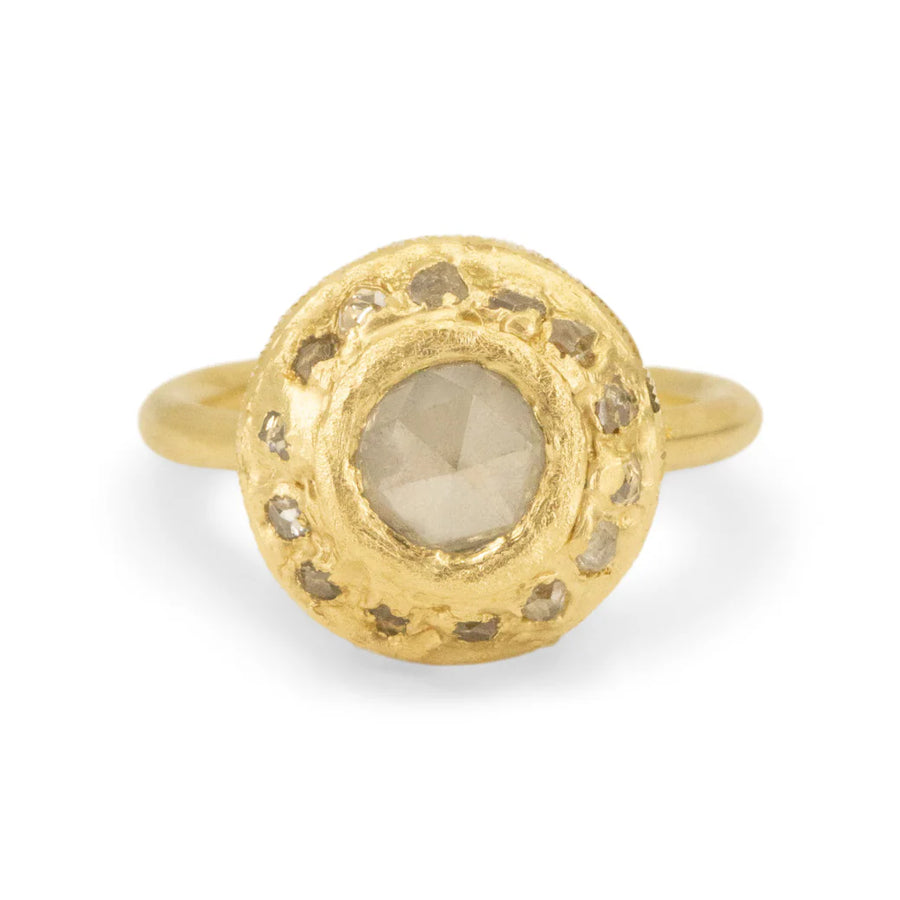 rose cut gray diamond at the center of a large disk of gold with small gray diamonds set all around it