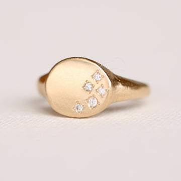 Five beadset diamonds give the impression of stars in the night on a round 14k gold signet ring