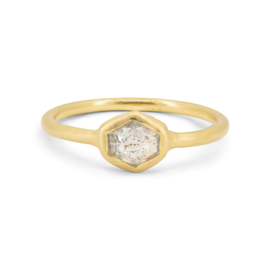 Gold ring with a hexagonal stone on a white background