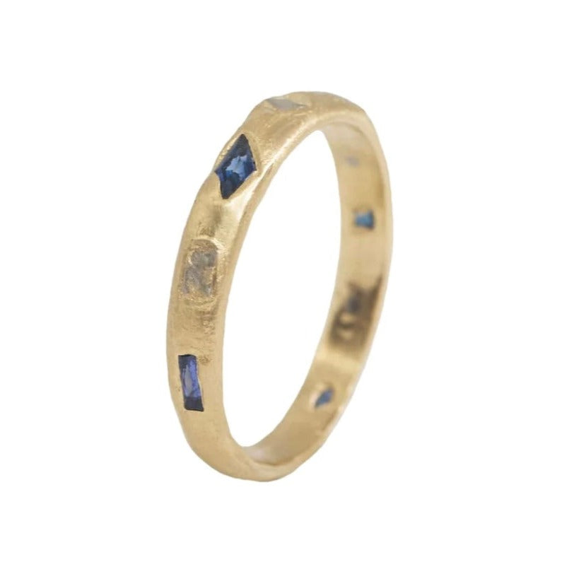 Gold band with different geometric shaped sapphire and white gold accents 3/4 around the ring