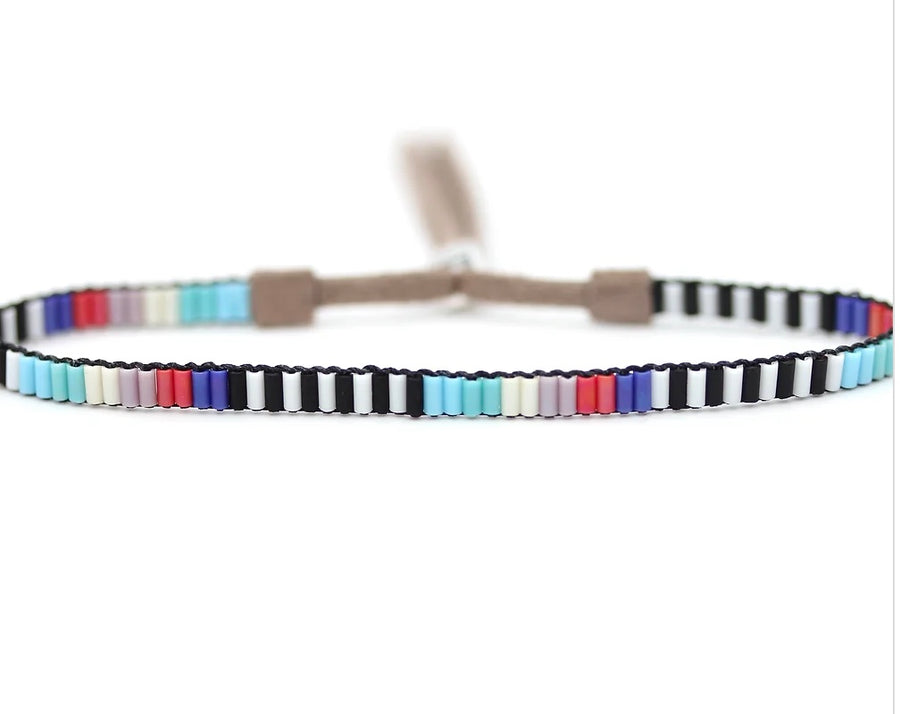 A close-up of Julie Rofman Jewelry's Mini Beaded Bracelets - 2 Strand with alternating black beads and a sequence of pink, blue, and red beads on a white background, featuring a sterling silver clasp.