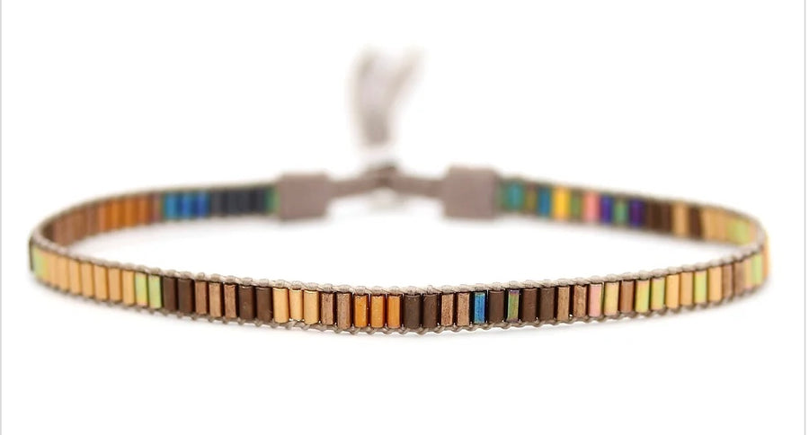 A slim multicolored Mini Beaded Bracelet - 2 Strand by Julie Rofman Jewelry on a white background, featuring a blend of earth tones and vivid colors, secured with a sterling silver clasp.