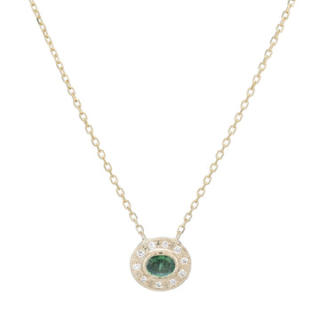 A small pendant with an oval emerald at the center, and a halo of white diamonds set around it.