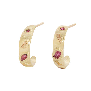 Gold hoop earrings with embedded pink ruby gemstones on a white background