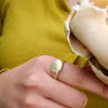 2 of 4: Hand with brass signet holding flower