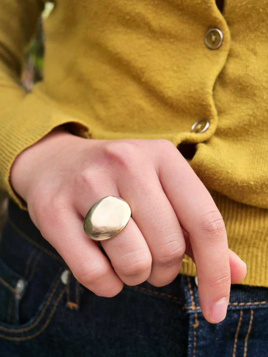 brass stone-shaped signet on hand