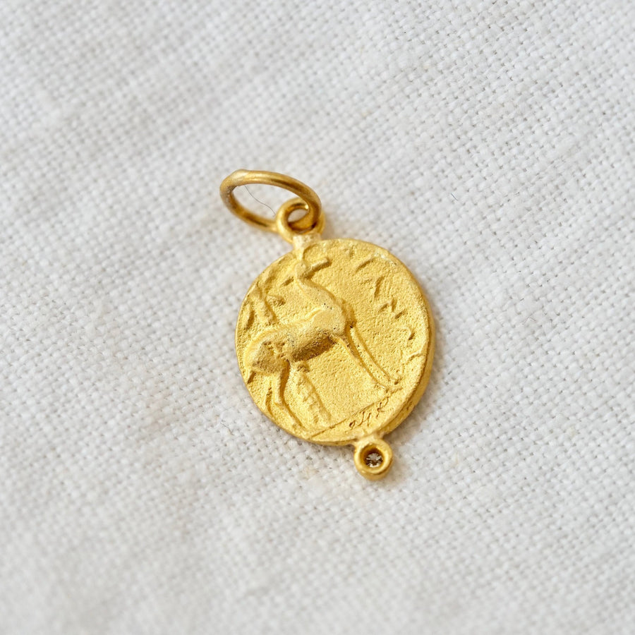 24k solid gold coin in bee embossed on one side and a deer embossed on the other, with two white diamonds