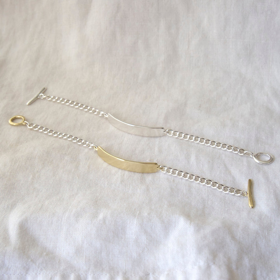 Gold and silver bracelet on a white fabric background