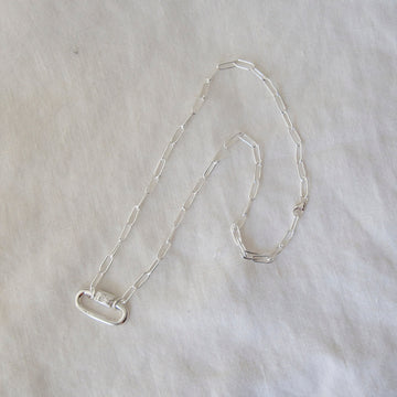 Silver chain necklace on a light gray background