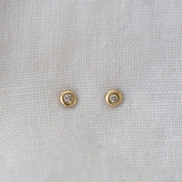 small white diamonds flush set in the center of soft gold dots