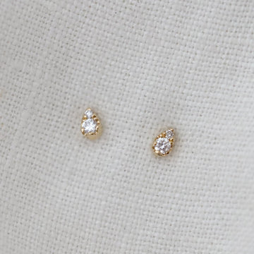 Pair of diamond stud earrings on a light fabric background