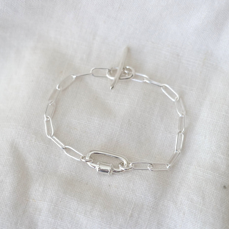 Silver chain bracelet on a white fabric background