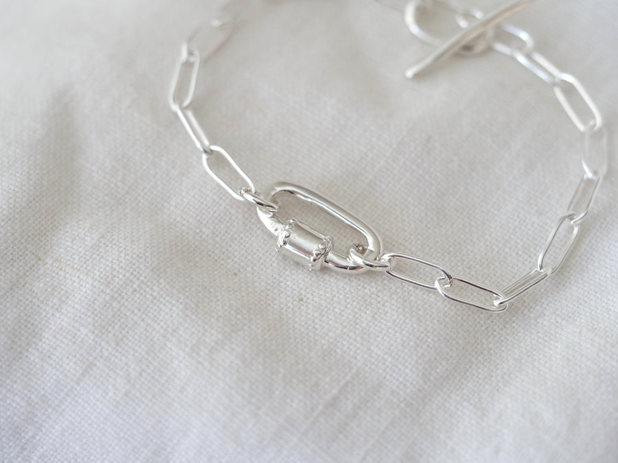 Silver bracelet on a light fabric background