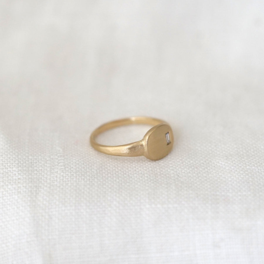 Gold ring on a white textured surface