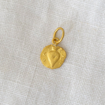 Gold pendant on a light fabric background