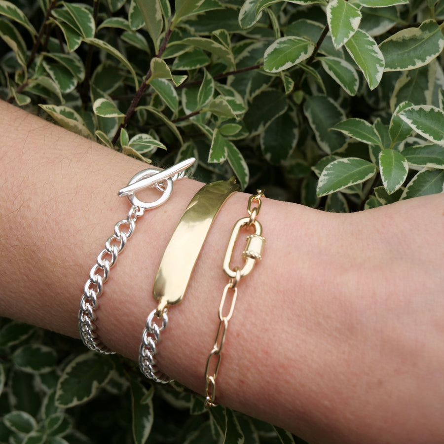 Three bracelets on a wrist with a green leafy background
