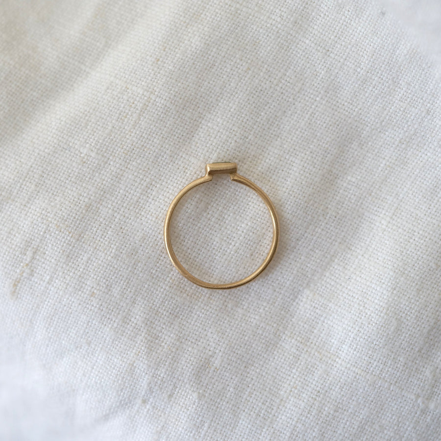 Gold ring on a textured beige fabric background